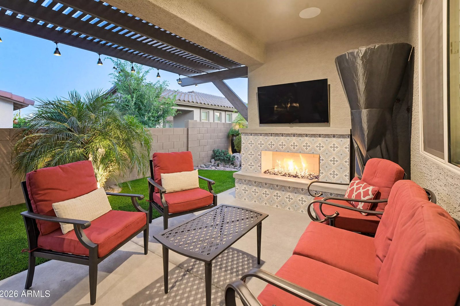 Covered patio with outdoor fireplace in a Surprise, Arizona brokerage listing