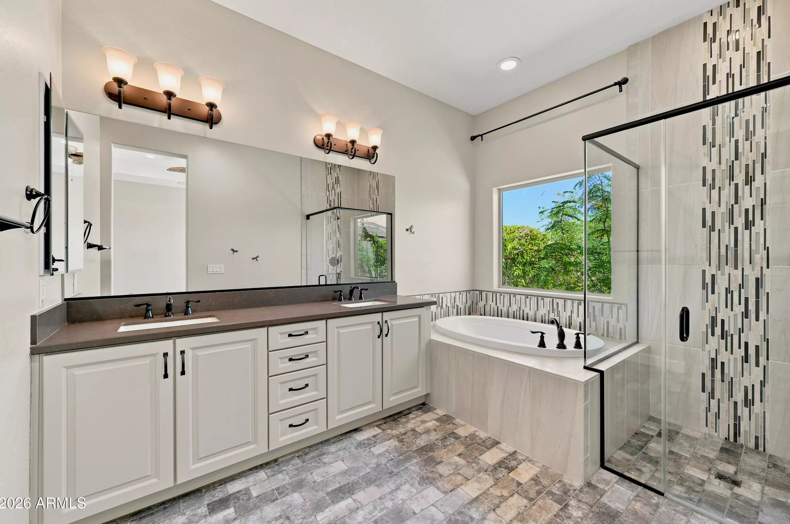 Primary bathroom with dual vanities and tiled shower in a Litchfield Park, Arizona brokerage listing